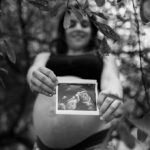 Diana Fajardo - sesión fotografía embarazo Coruña mujer embarazada sujetando una imagen de una ecografía con barriga de fondo en blanco y negro